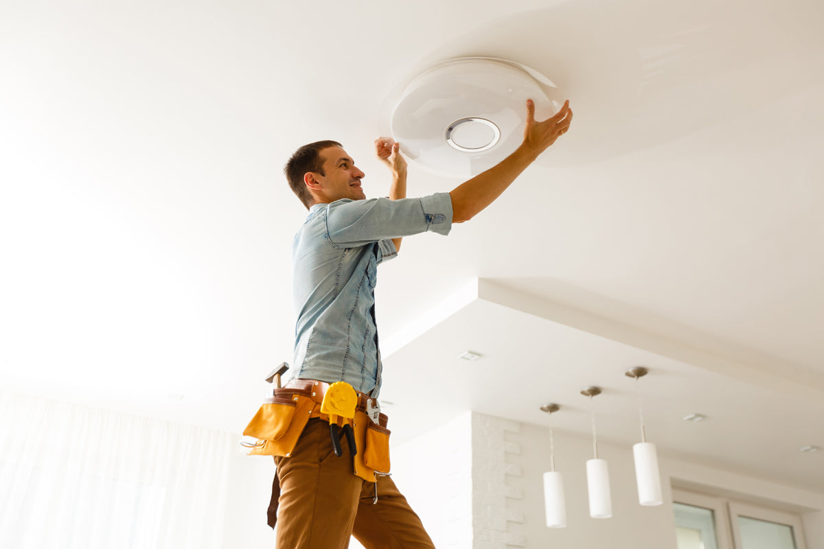 Professional Electrician shown replacing a flush mounted ceiling light fixture.