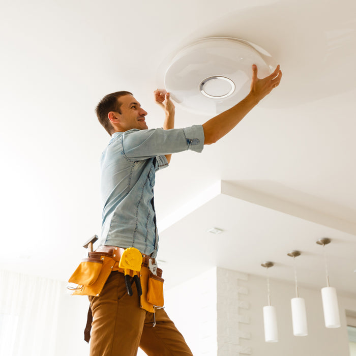 Professional Electrician shown replacing a flush mounted ceiling light fixture.