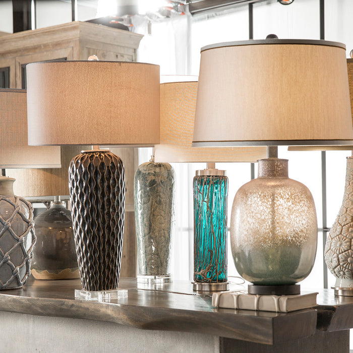 Various styles & sizes of designer tables lamps showcased on a console table.