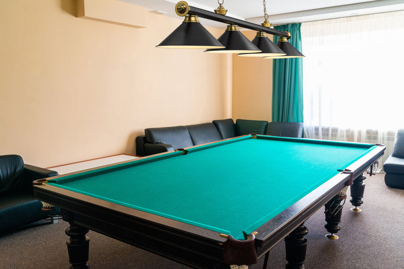 Cordon 4 Light 81.25" Billiard, Matte Black + Rubbed Brass with Matte Black Shades in Matte Black + Rubbed Brass in a room setting