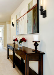 Beau 1 Light 4.5" Wall Sconce, Clear Shade in Bronze in a room setting