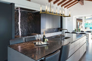 Beau 9 Light 56" Linear Pendant in Rubbed Brass in a room setting