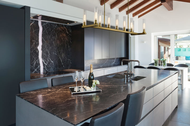 Beau 9 Light 56" Linear Pendant in Rubbed Brass in a room setting