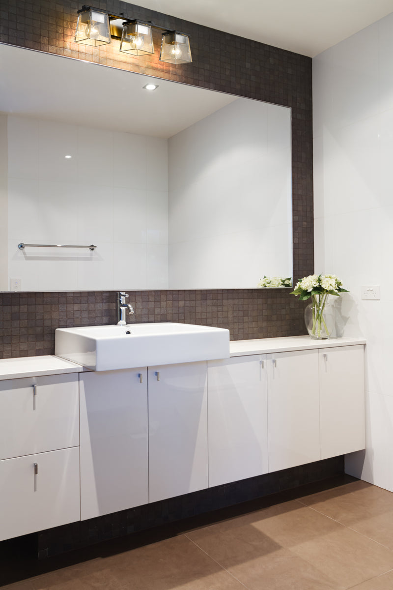 Bleeker Street 3 Light 25" Vanity in Matte Black + Brushed Nickel in a room setting