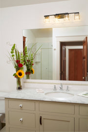 Bleeker Street 4 Light 33" Vanity in Matte Black + Olde Brass in a room setting
