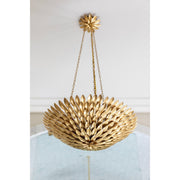 Broche 6 Light 24.5" Chandelier in Antique Gold in a room setting