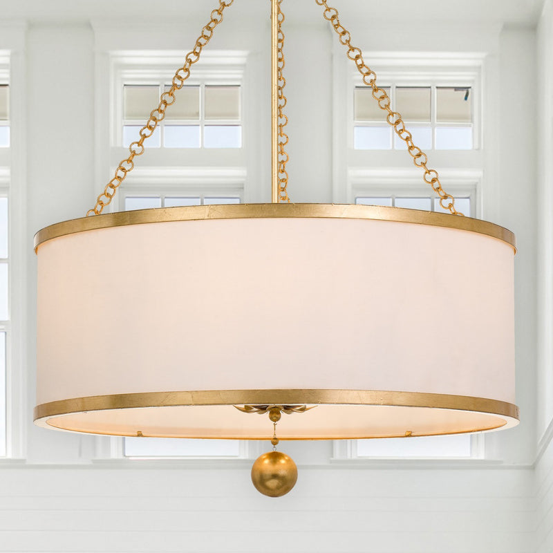 Broche 6 Light 24" Chandelier in Antique Gold in a room setting