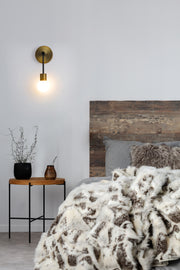 Neutra 1 Light 6" Wall Sconce in Matte Black + Foundry Brass in a room setting
