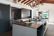 Neutra 5 Light 44" Linear Pendant in Matte Black + Polished Nickel in a room setting