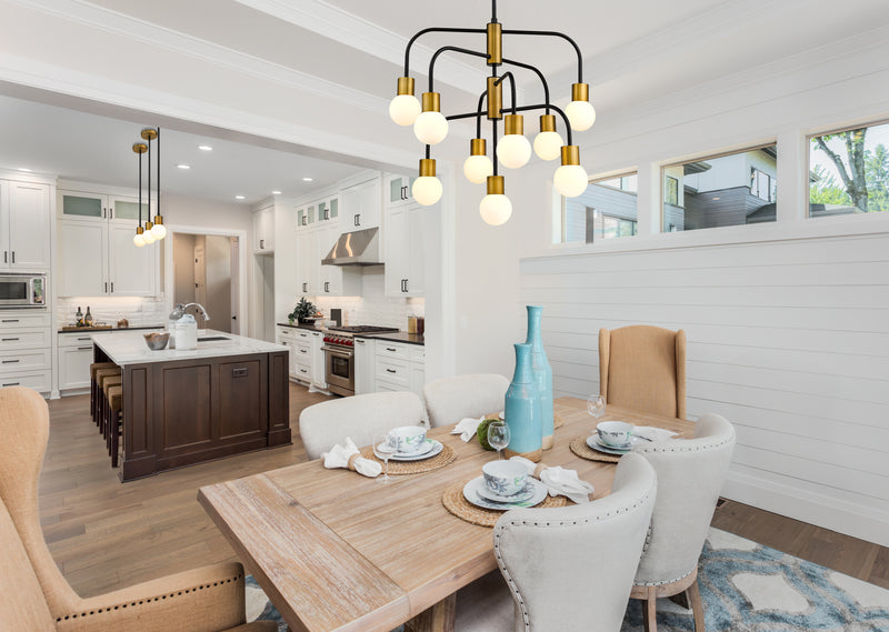 Neutra 9 Light 26.5" Chandelier in Matte Black + Foundry Brass in a room setting