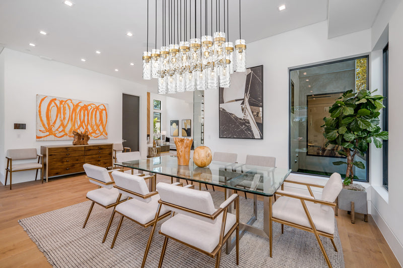 Fontaine 23 Light 54.5" Linear Pendant in Rubbed Brass in a room setting