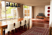 Soriano 6 Light 48" Linear Pendant in Matte Black + Heritage Brass in a room setting