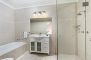 Vaughn 3 Light 22.5" Vanity in Brushed Nickel in a room setting