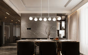 Realm Sphere 7 Light 54" Linear Pendant in Brushed Nickel in a room setting
