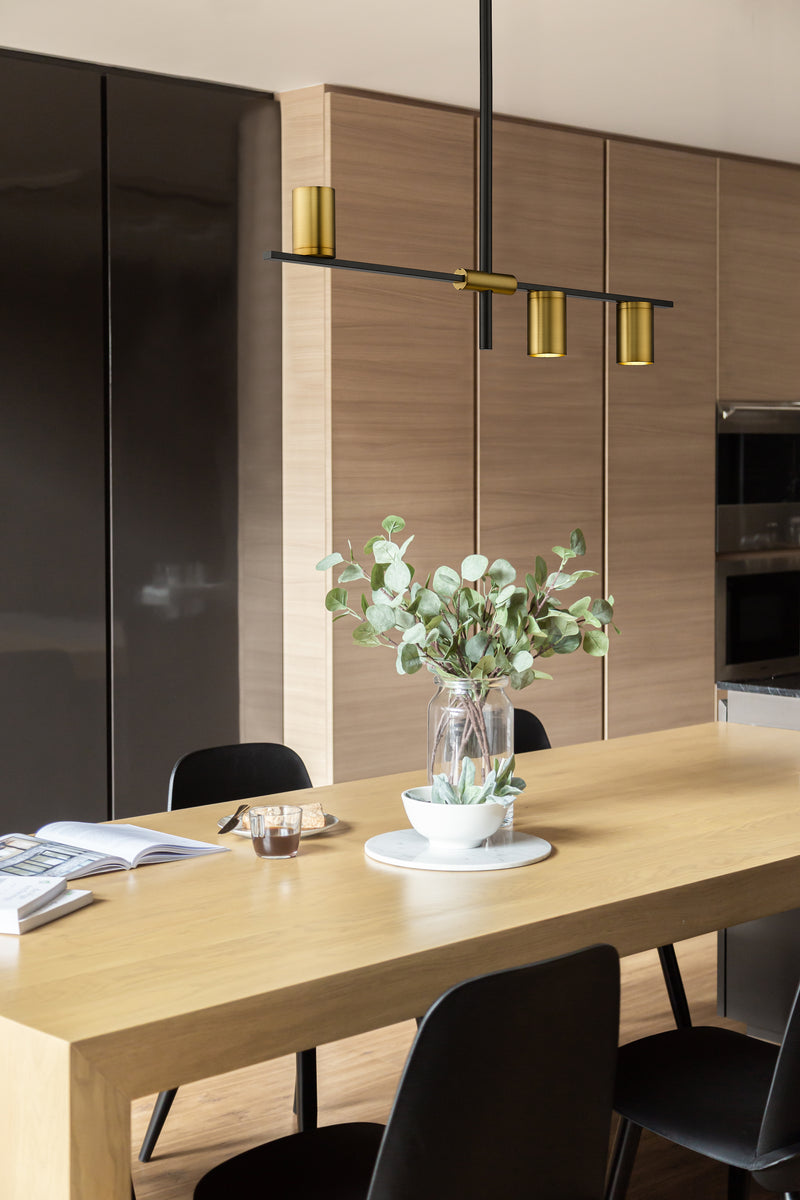 Calumet 3 Light 32" Linear Pendant in Matte Black + Olde Brass in a room setting