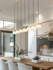 Renaud 7 Light 58.75" Linear Pendant in Modern Gold in a room setting