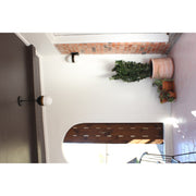Capsule 1 Light 6" Outdoor Sconce in Matte Black + Textured Gold in a room setting