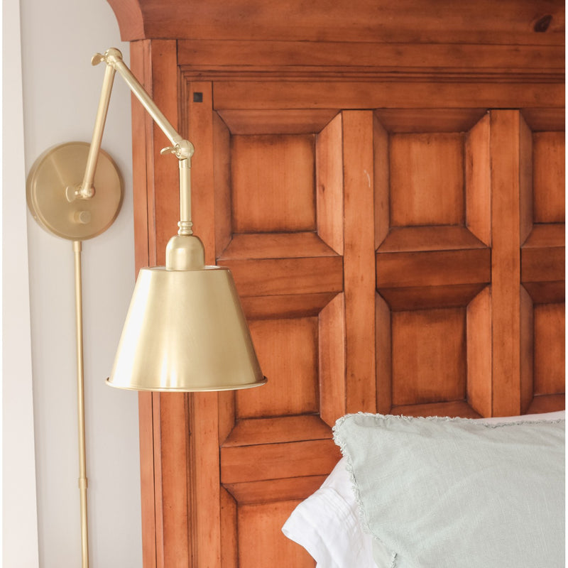 Mitchell 1 Light 7.25" Task Sconce in Aged Brass in a room setting
